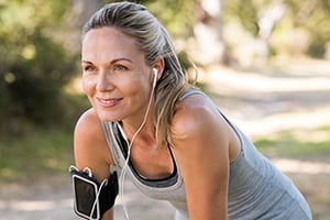 A healthy, young woman is taking a break from jogging. 